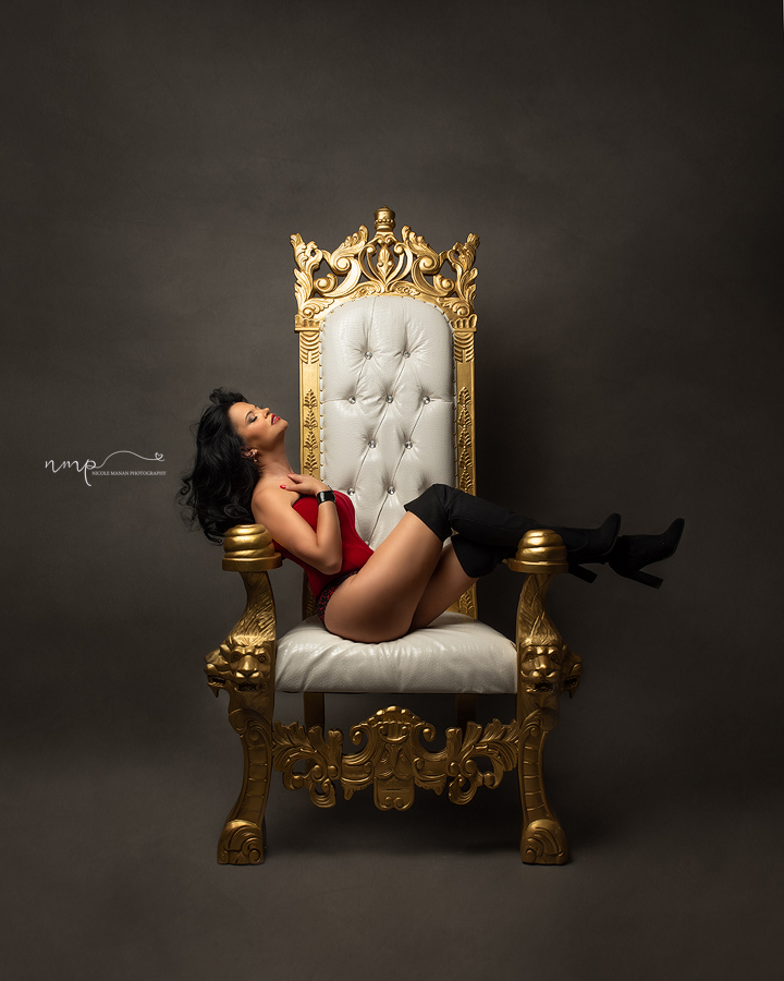 A woman in a corset posing on a golden throne during her Coluumbus GA boudoir session.