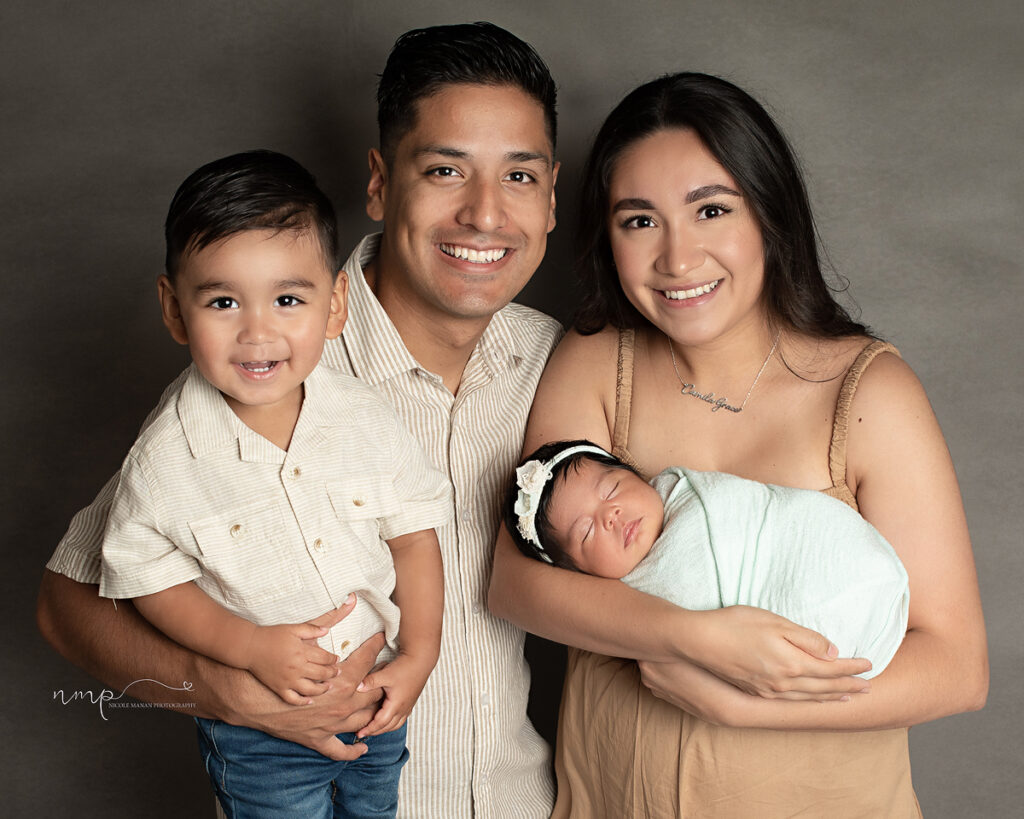A family with a little boy and a newborn girl posing for a family picture during their Columbus GA newborn session
