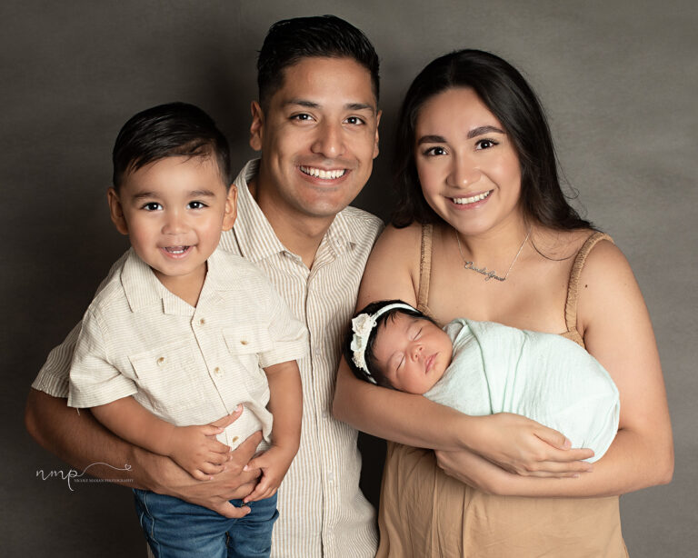 A family with a little boy and a newborn girl posing for a family picture during their Columbus GA newborn session