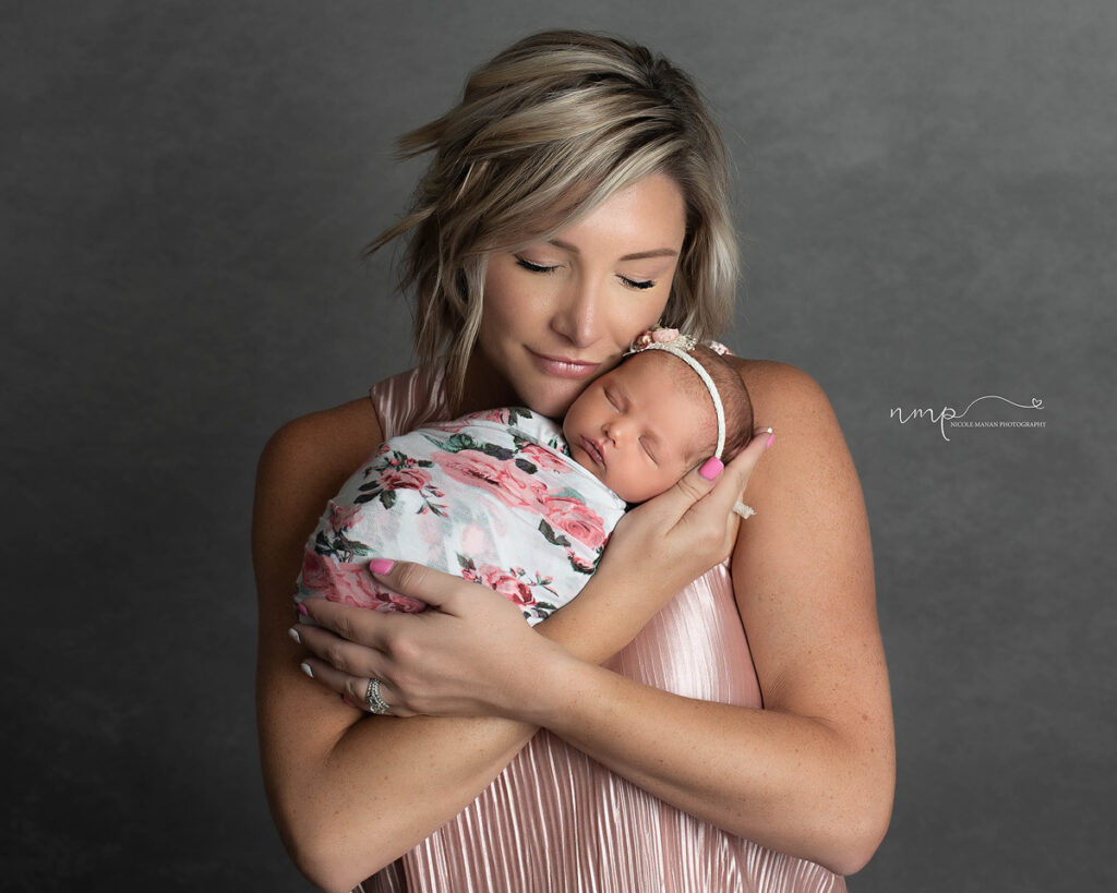 A woman holding her newborn baby girl in her arms during her Columbus GA newborn session