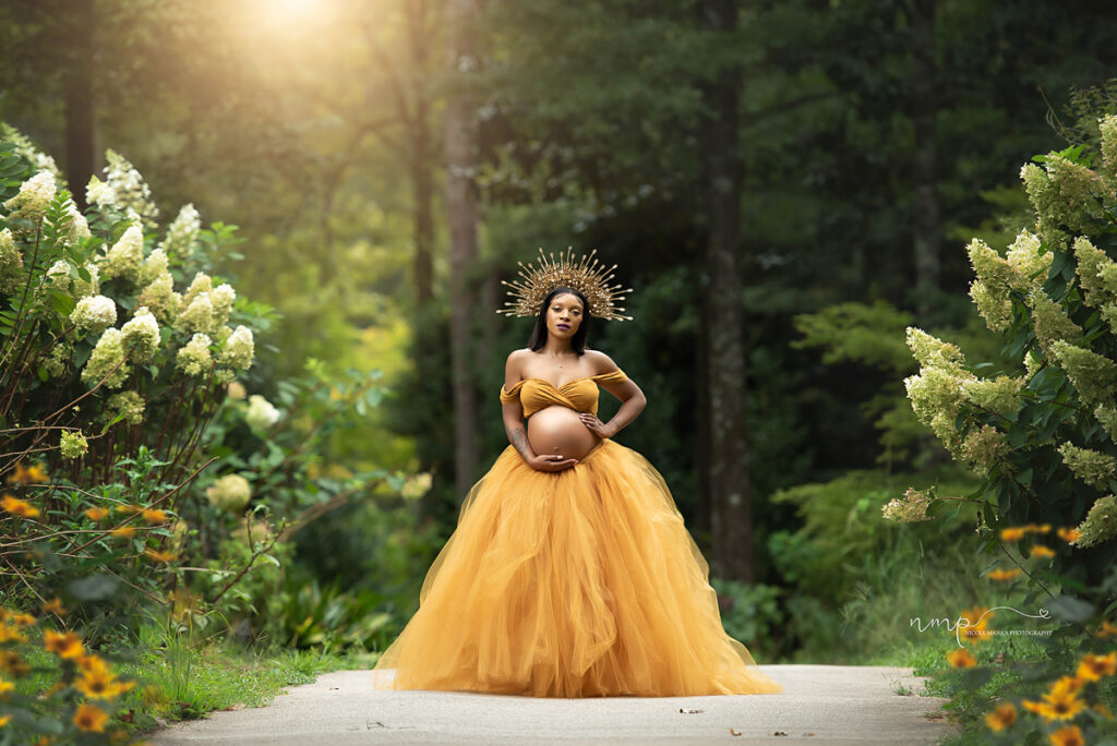 Pregnant woman during outdoor maternity session at Callaway Gardens in a beautiful maternity gown and a goddess crown.
