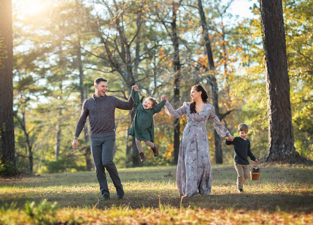 A family laughing and walking in a park during their Columbus GA family session