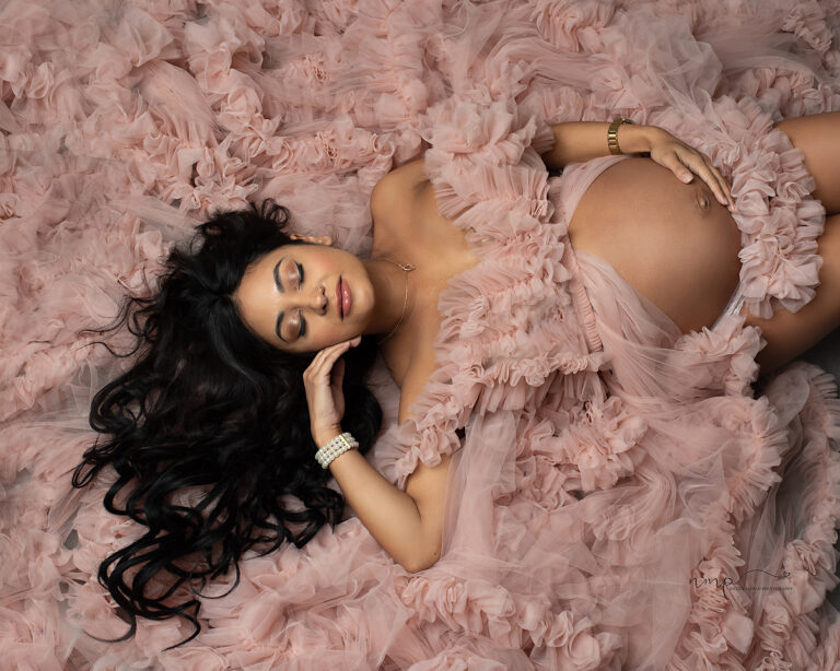 Pregnant woman in beautiful ruffle maternity dress lying on the floor during her Columbus GA maternity session