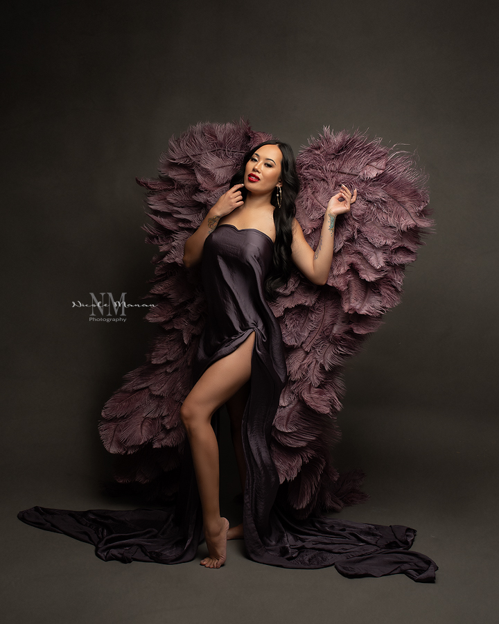 A woman in purple giant angle wings posing during her Columbus GA boudoir session