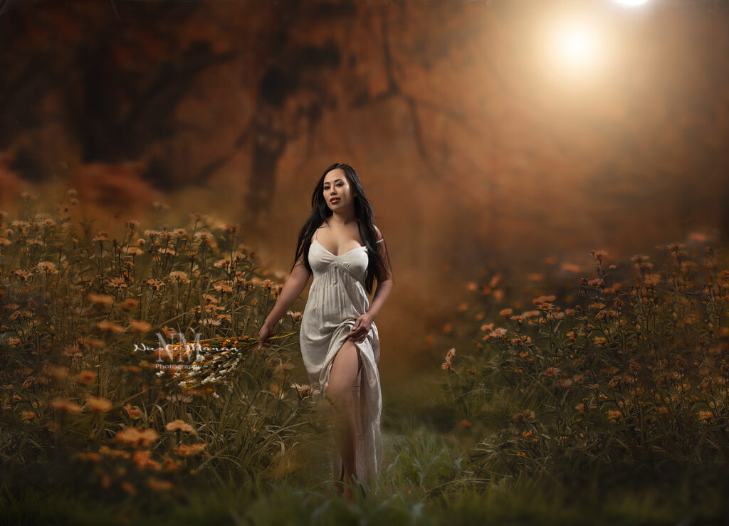 A woman in a sommerdress walking through a flower field at golden hour during her Columbus Ga photo session.